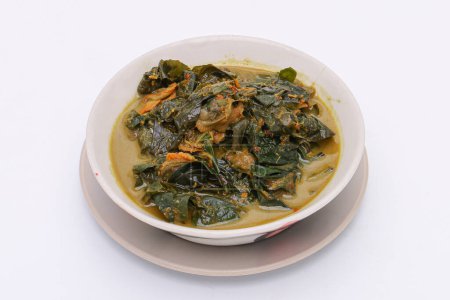 Téléchargez les photos : Curry de coques avec des feuilles de bétel dans un bol sur un fond blanc isolé. De la nourriture thaïlandaise. Vue du dessus. - en image libre de droit