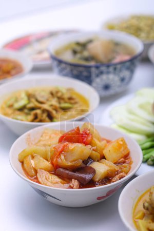 Téléchargez les photos : Sauce aigre-douce frite avec des légumes dans un plat blanc sur fond blanc isolé. De la nourriture thaïlandaise. Vue du dessus. - en image libre de droit
