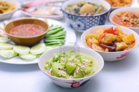 Téléchargez les photos : Mélanger les courgettes frites avec les œufs dans un plat blanc dans un bol sur l'ensemble des assiettes de groupe nourriture thaïlandaise. Vue de dessus. vue verticale - en image libre de droit