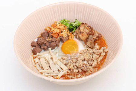 Téléchargez les photos : Nouilles de riz vietnamiennes Soupe aux œufs à la coque molle, au boudin de sang, au porc haché, à la saucisse de porc tranchée, aux côtes de porc et à la pâte de chili dans un bol sur fond blanc - en image libre de droit