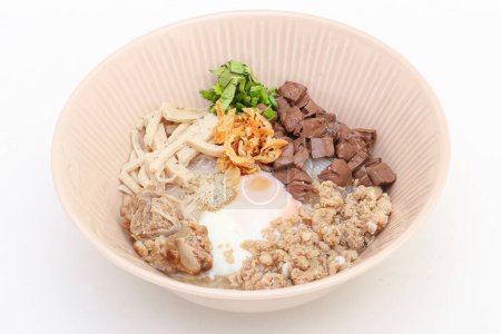 Téléchargez les photos : Nouilles de riz vietnamiennes Soupe aux œufs à la coque molle, boudin de sang, porc haché, saucisse de porc tranchée et côtes de porc dans un bol sur fond blanc - en image libre de droit
