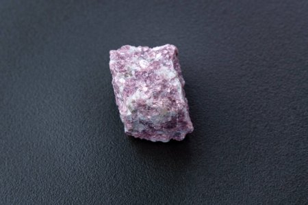 Foto de Piedra de lepidolita sobre fondo negro, siendo una fuente secundaria de litio, utilizada en baterías - Imagen libre de derechos