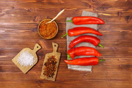 Photo for Ajvar from sweet peppers, eggplant, tomatoes, garlic and onions with spices wooden table. Balkan food. Flat lay - Royalty Free Image