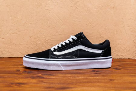 Photo for Tyumen, Russia-August 03, 2023: Brand new black and white Vans Old Skool shoes. Brown background - Royalty Free Image