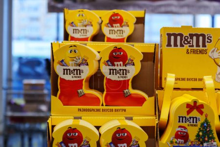 Foto de Tyumen, Rusia-Noviembre 04, 2023: M y Ms coloridos caramelos de chocolate en forma de botón. Regalos para el nuevo año. Enfoque selectivo - Imagen libre de derechos