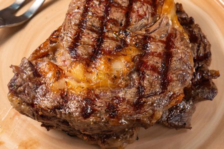 Téléchargez les photos : Succulent steak grillé sur une assiette capturé. Concentration sélective - en image libre de droit