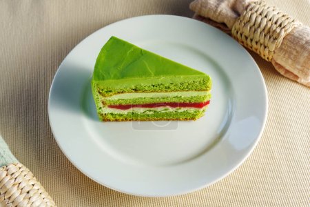 Téléchargez les photos : Présentant un morceau délicieux de gâteau vert sur une assiette blanche immaculée, tentant le spectateur - en image libre de droit