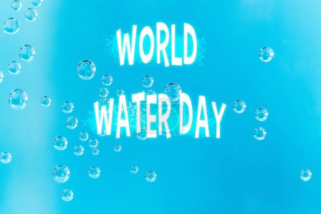 Foto de Día Mundial del Agua con gotas de rocío en una superficie azul, haciendo hincapié en la hidratación y la conservación - Imagen libre de derechos