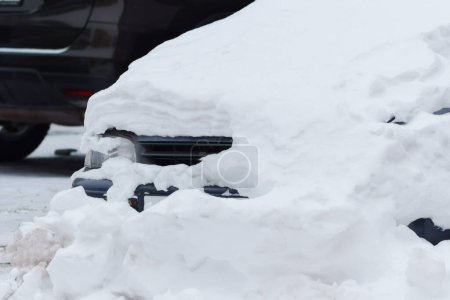 Auto, bedeckt von einer dicken Schneeschicht, steht als Beweis für das kühle Winterwetter