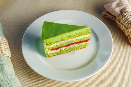 Showcasing a delectable piece of green cake on a pristine white plate, tempting the viewer