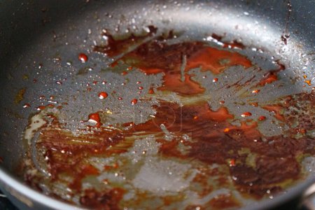 Detailed view of a frying pan filled with sizzling food being cooked