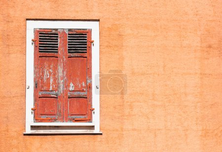 Red wooden vintage shutters and stone wall, traditional European architectur