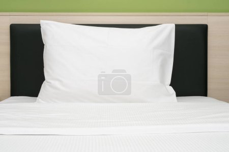 Téléchargez les photos : White clean pillow on a bed at a hotel room, front view - en image libre de droit