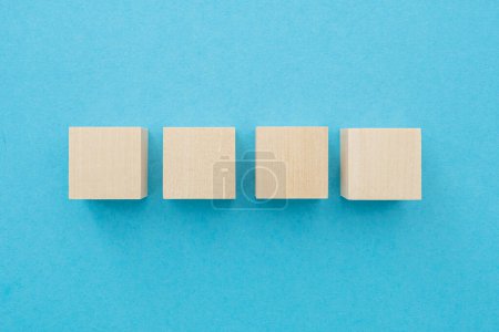 Téléchargez les photos : Four wooden cubes, square shape with blank surface on blue background, for business concept ideas - en image libre de droit