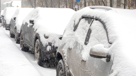 Photo pour Row of cars covered by snow during heavy snow storm in the city - image libre de droit