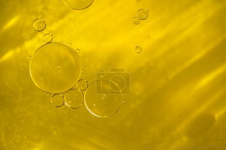 Photo for Close-up of liquid golden oil, serum with bubbles as texture or background - Royalty Free Image