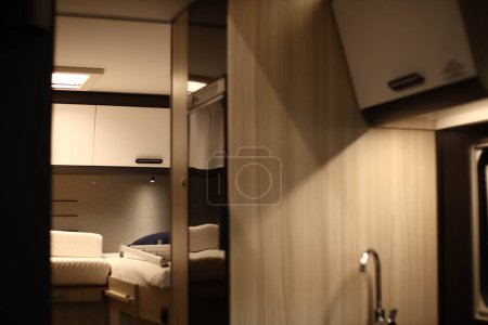 Interior design of a kitchen in a camper on wheels. Caravan, motorhome. Mobile home. Stove and furniture