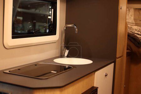 Innenarchitektur einer Küche in einem Wohnmobil auf Rädern. Wohnwagen, Wohnmobil. Mobilheim. Herd und Möbel