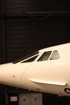 A supersonic aircraft with a nose down. White modern airplane