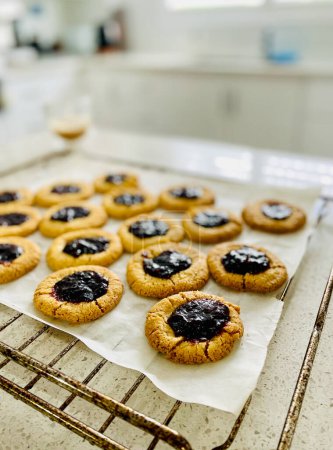 Téléchargez les photos : Confiture fraîchement cuite déposer les biscuits refroidissement sur un support de cuisson dans la cuisine - en image libre de droit