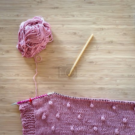 Photo for Knitting needles with pink wool on a wooden background - Royalty Free Image
