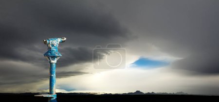 Foto de Binoculares públicos y el ojo azul de la tormenta. Clima extremo en Islandia. Pronóstico y visión del concepto y las ideas empresariales nuevas y creativas. - Imagen libre de derechos