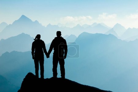 Foto de Couple in love standing on mountain peak holding hands. Man and woman enjoying sunrise after successful hiking trip reaching mountain top. Tirol, Austria. Allgau, Bavaria. - Imagen libre de derechos
