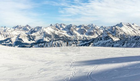 Foto de Hombre senderismo con raquetas de nieve en el hermoso paisaje de montaña de invierno. Alpes, Alemania, Baviera, Allgaeu. - Imagen libre de derechos