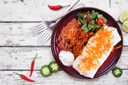 Foto de Placa de burrito con arroz mexicano y frijoles refritos. Escena de mesa vista aérea sobre fondo de madera blanca. - Imagen libre de derechos