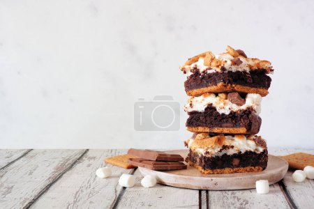 Téléchargez les photos : Une pile de barres à dessert brownie smores. Scène de table vue de côté avec un fond blanc. - en image libre de droit