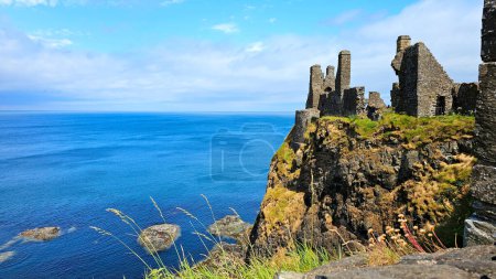 Photo for Ruins of the medieval Dunluce Castle overlooking the blue North Atlantic ocean. Causeway Coast, Northern Ireland. - Royalty Free Image