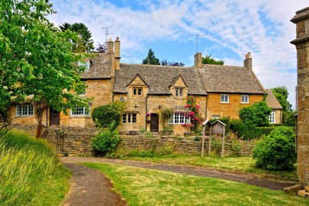 Photo for Pretty Cotswolds village under blue skies, Bourton on the Hill, Gloucestershire, England - Royalty Free Image