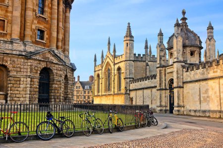 Oxford University at dusk, England, UK. Radcliffe Camera and All Souls College with bicycles on cobblestone streets.