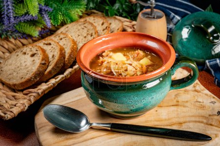 Traditional sour cabbage soup on wooden table.