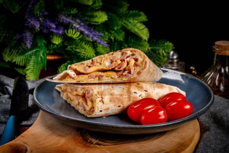 Téléchargez les photos : Tortilla multigrain avec omelette, saucisse et bacon. Profondeur de champ faible. - en image libre de droit