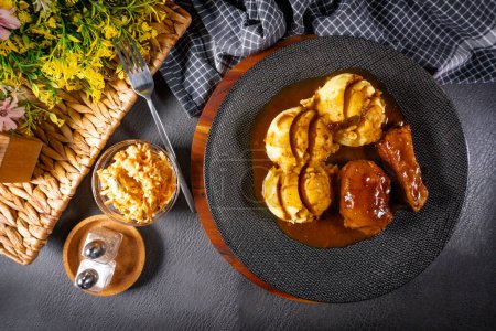 Mejillas de cerdo estofadas alemanas tradicionales en salsa marrón servidas con puré de papas.