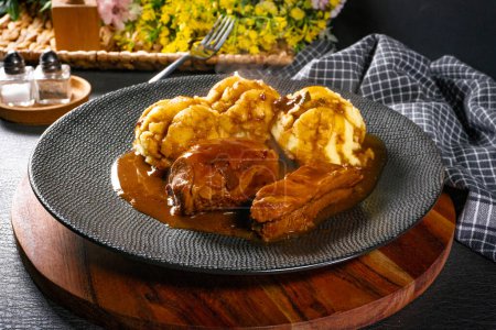 Traditional German braised pork cheeks in brown sauce served with mashed potatoes.