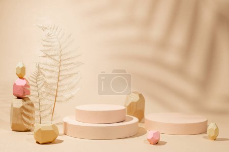 Photo for Composition of  geometric podiums, balancing wooden stones and dried leaves for products presentation or exhibitions. Tropical leaf shadow on sand color background - Royalty Free Image