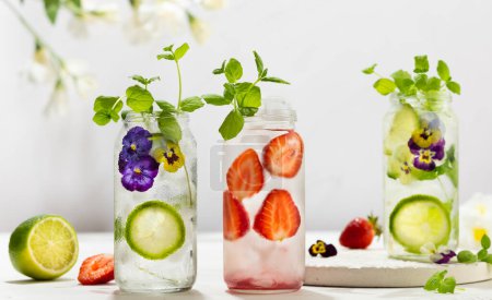 Photo for Cold Infused detox water with edible flowers, strawberry and mint leaves. Refreshing summer drink. - Royalty Free Image