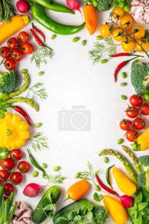 Foto de Verduras y hierbas frescas variadas sobre fondo blanco. Alimentación sana, limpia, vegetariana o dietética. Vista superior, espacio de copia. - Imagen libre de derechos