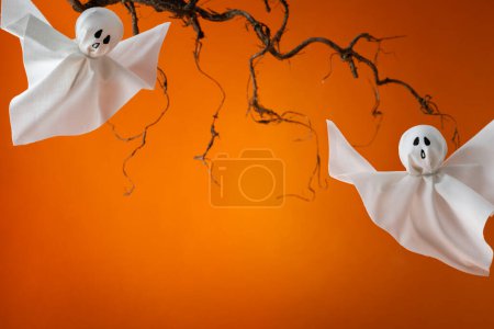 Téléchargez les photos : Fantômes d'Halloween sur fond orange. Joyeux concept de vacances d'Halloween. Décoration faite à la main pour fête de festival. - en image libre de droit
