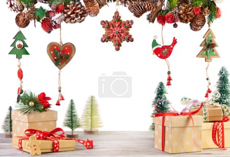 Téléchargez les photos : Scène de Noël ou du Nouvel An avec boîtes cadeaux et guirlande de branches de sapin, baies rouges, cônes de pin et autres ornements en bois. - en image libre de droit
