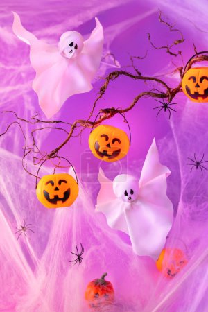 Téléchargez les photos : Halloween fantômes et seaux à citrouille pour bonbons sur fond violet néon. Concept de fête d'Halloween. Décorations de vacances drôles. - en image libre de droit