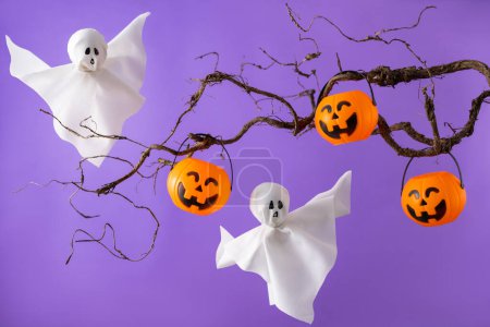 Téléchargez les photos : Seaux de citrouille Halloween pour bonbons et fantômes blancs sur fond violet. Concept de fête d'Halloween. Décorations de vacances drôles. - en image libre de droit