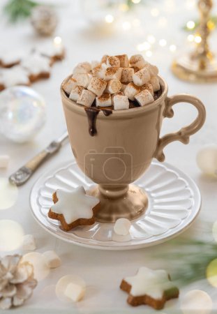Téléchargez les photos : Tasse de chocolat chaud avec guimauve, biscuits et cannelle sur la table de fête. Tradition Noël hiver boisson sucrée. - en image libre de droit
