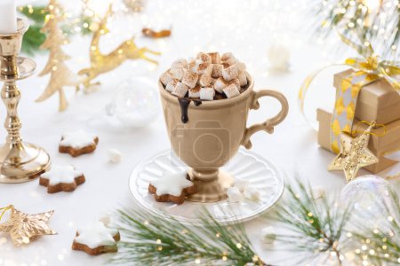 Téléchargez les photos : Coupe de chocolat chaud avec guimauve, biscuits et cannelle sur la table de fête décorée pour Noël.. - en image libre de droit