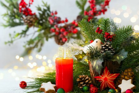 Téléchargez les photos : Carte de voeux de Noël avec bougies rouges, boules et décorations de Noël, biscuits à la cannelle, cônes de pin et branches. Concept vacances d'hiver. - en image libre de droit