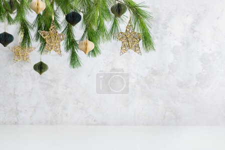 Téléchargez les photos : Composition de Noël ou du Nouvel An pour la décoration intérieure de la maison. Branches de sapin et décorations d'hiver sur scène vide. Boules de papier et étoiles d'or Noël. - en image libre de droit
