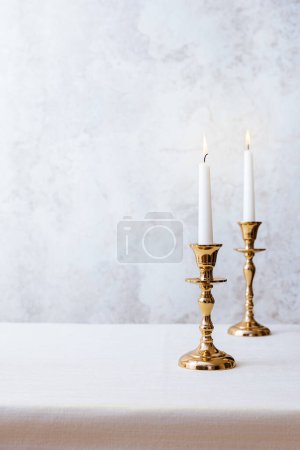 Photo for Cozy still life with burning candles in golden candlesticks on pastel light background. Concept Christmas Advent. - Royalty Free Image