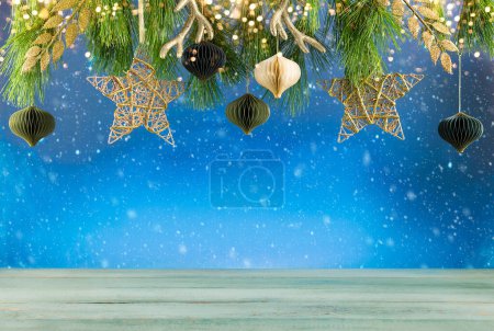 Photo for Christmas or New Year festive composition. Fir branches , gold Christmas decorations and paper balls over empty wooden table. - Royalty Free Image